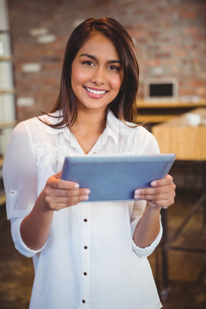 istock Smiling young businesswoman holding a tablet 668137524