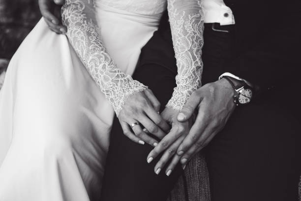 istock Bride and groom tenderly hold each other's hands. BW tone 668139850