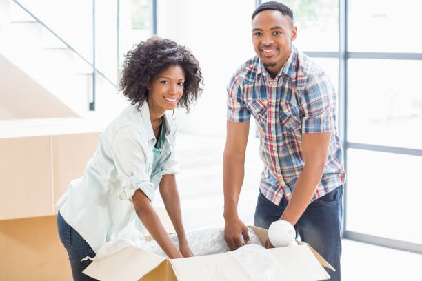 istock Young couple unpacking carton boxes 668147292
