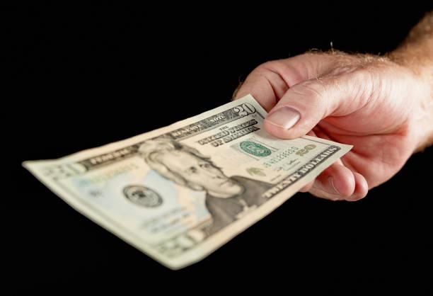 masculino mão segurando notas de dólar americano de vinte - twenty dollar bill human hand paper currency number 20 - fotografias e filmes do acervo