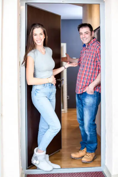 Welcome to the house. Young married couple at the front door of his apartment. Man and woman in love