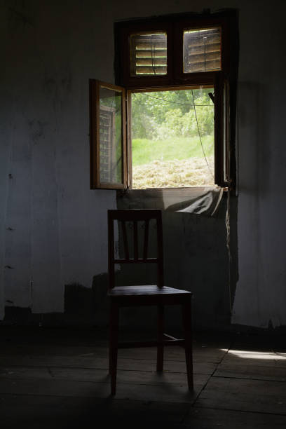 istock Chair in front of window with mosquito netting. Low key. 668151624