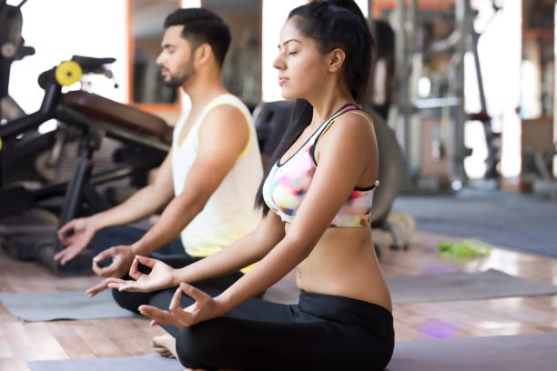 istock Fit young couple meditating 668154202