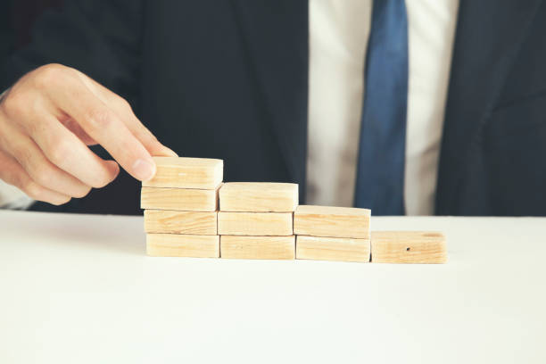istock a business man build a blocks wood game 668161756