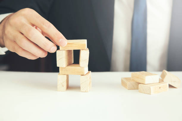 istock Man hand holding a missing piece in a square tangram puzzle 668161776