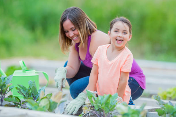 istock Daughter Smiling At Camera In Garden 668161788