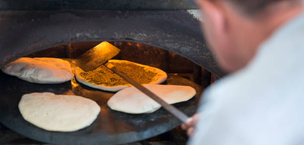 istock Man preparing pita bread in oven. 668164820