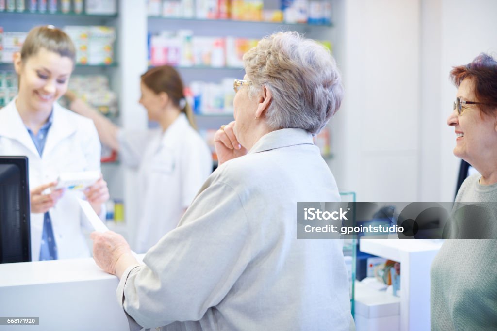 Customers been waiting on the queue in drug store Pharmacy Stock Photo