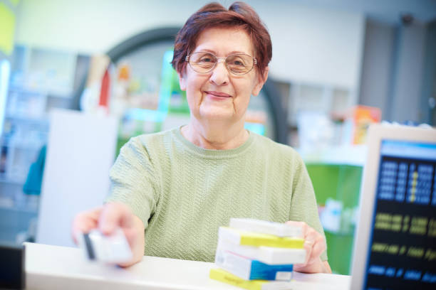 cliente senior sonriente en farmacia - pharmacist mature adult smiling senior adult fotografías e imágenes de stock