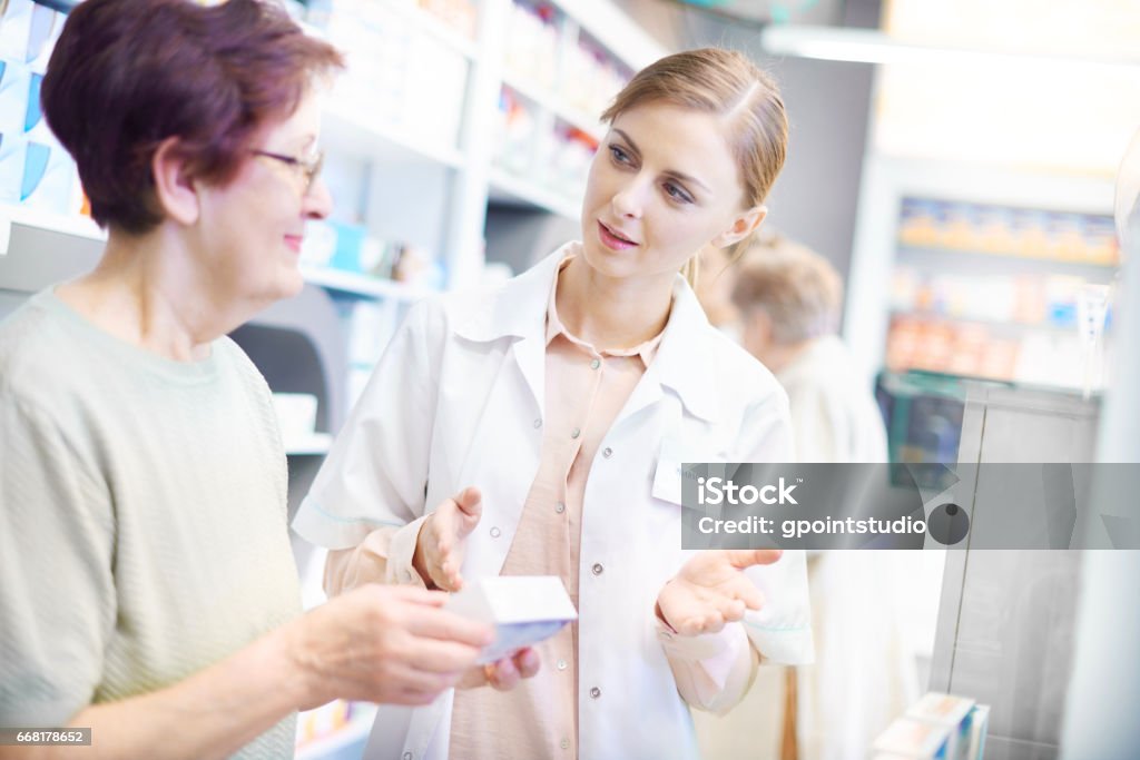 Customer discussing product with pharmacist Pharmacist Stock Photo