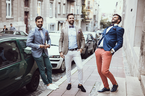 Three young good looking tailors laughing on the street
