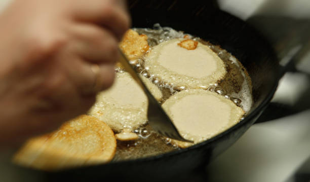 proces gotowania flapjacks ziemniaków na patelni z wrzącym olejem słonecznikowym z bliska z rozmyciem ruchu - pan fried angle black zdjęcia i obrazy z banku zdjęć
