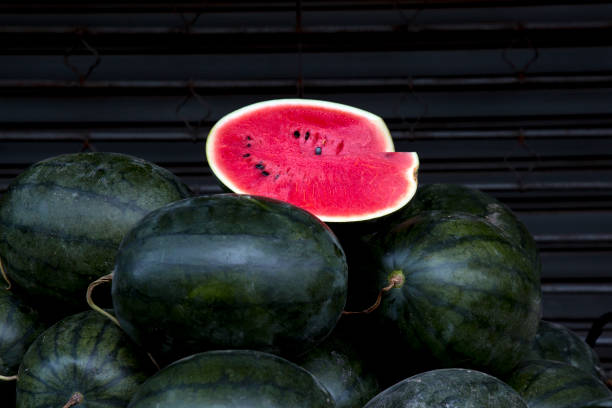 watermelon slice.Many big sweet green watermelons and one cut watermelon. stock photo