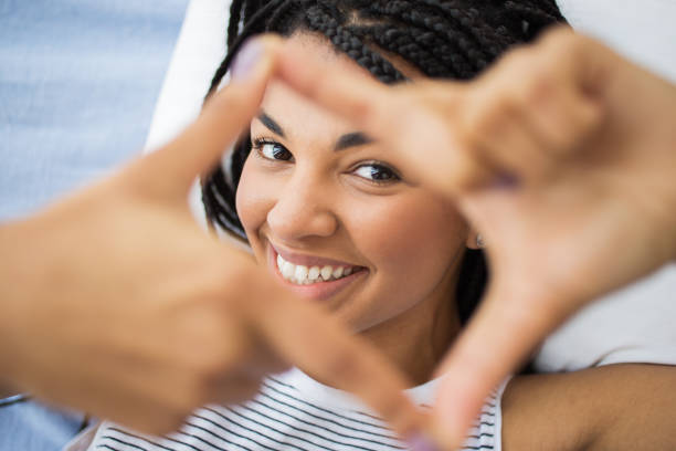 istock Smiling young woman making frame with fingers 668186030