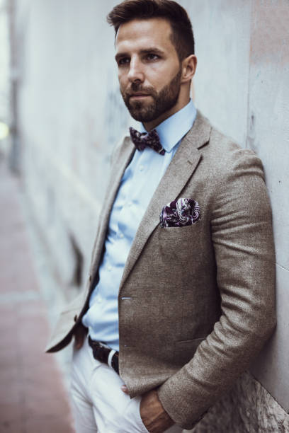 istock Attractive bearded man with hands in pockets leaned on the wall 668188572