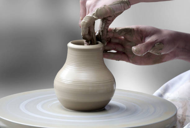 hands making ceramic cup Woman's hands making ceramic cup on potter's wheel pottery photos stock pictures, royalty-free photos & images