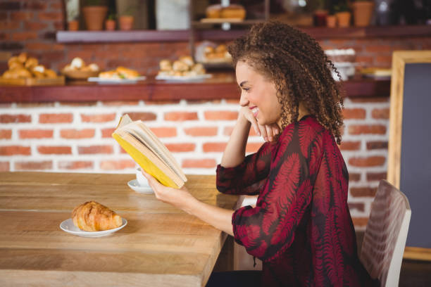 istock Young happy woman reading a book 668189848