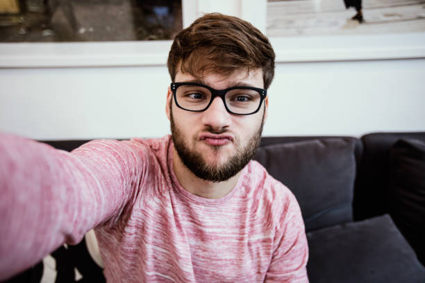 istock Hipster with glasses making duckface selfie 668190732