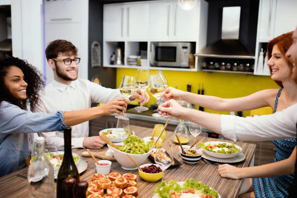 istock Group Of Friends Enjoying drinks while having Dinner At Home 668193822