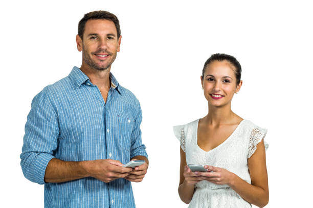 istock Smiling couple using smartphones and looking at camera 668193974