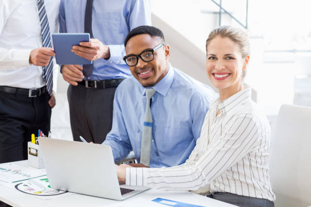 istock Business colleagues using laptop and digital tablet at desk 668197992