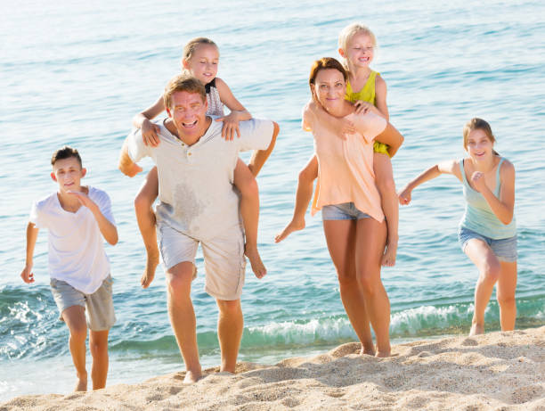 istock Parents with children walk on beach 668198134