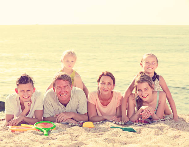 istock Parents with children lying on sand 668198162