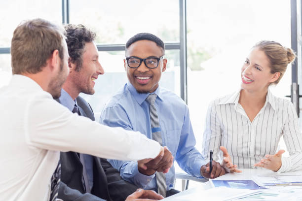 istock Businessman shaking hands with colleagues in meeting 668200482