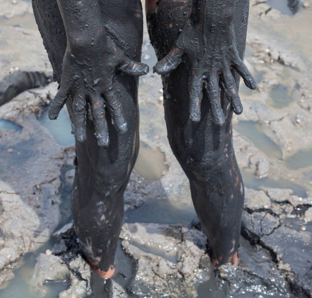 istock Hands and legs smeared with black healing mud 668204906