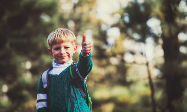 istock little boy with backpack enjoy travel in green forest 668208236