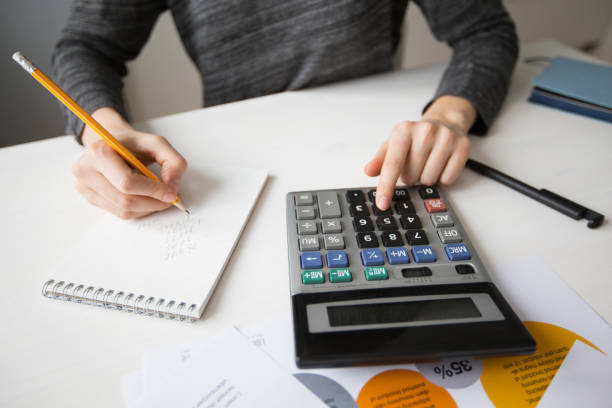 istock Closeup of Economist Using Calculator and Writing 668208692