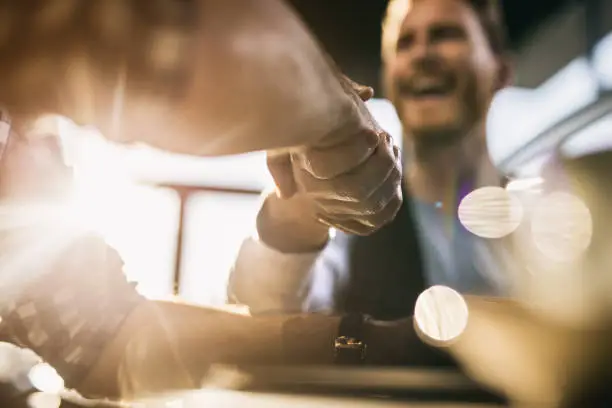 Close up of two businessmen shaking hands after successful agreement.