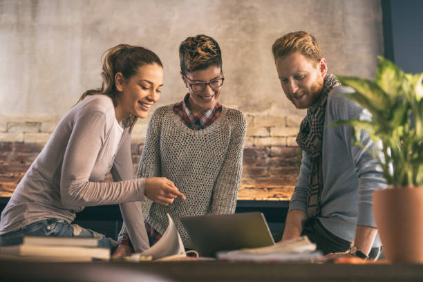 istock Young start up team using laptop in casual office. 668211958