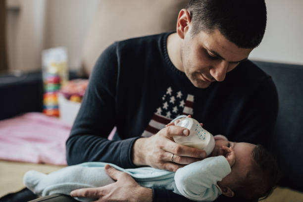 istock Father feeds son from baby bottle 668214522