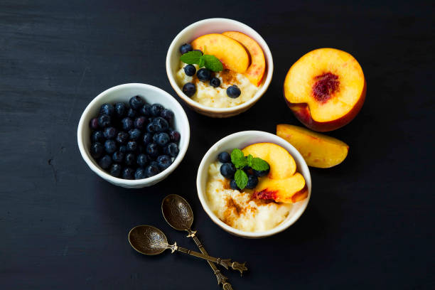 istock Pudding dessert bowls with peaches and blueberries, mint leaves decorated 668225702