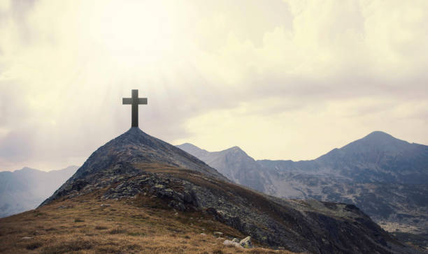 istock Christian cross on top of the hill with sunrays, crucifixion, religious concept 668225708