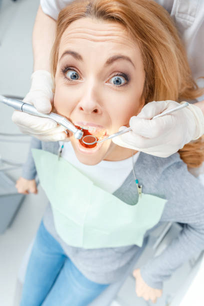 istock Close-up partial view of dentist curing scared patient in clinic 668236834