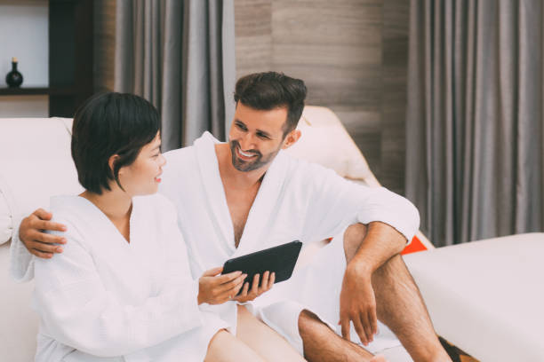 istock Smiling young couple using tablet in spa salon 668242974