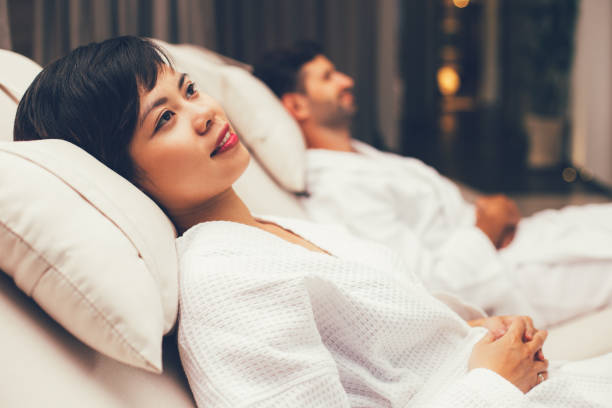 istock Smiling woman and man lying on deckchairs in spa 668242986