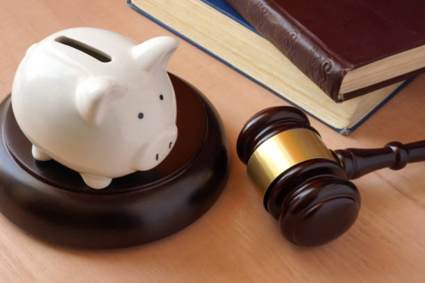 istock Piggy bank, gavel and books on a table. 668243634