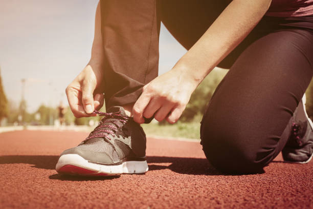 istock Sportswoman tying laces on sneakers. 668243946