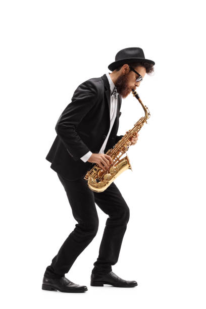 Bearded man playing a saxophone Full length profile shot of a bearded man playing a saxophone isolated on white background full body isolated stock pictures, royalty-free photos & images