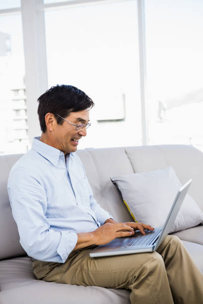 istock Smiling man at home on couch 668253548