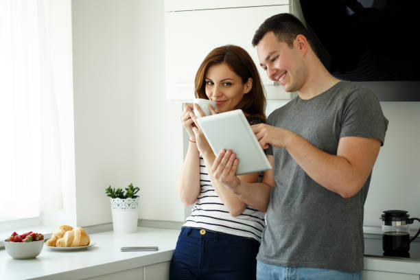 istock Attractive couple using digital tablet in their new kitchen 668253946