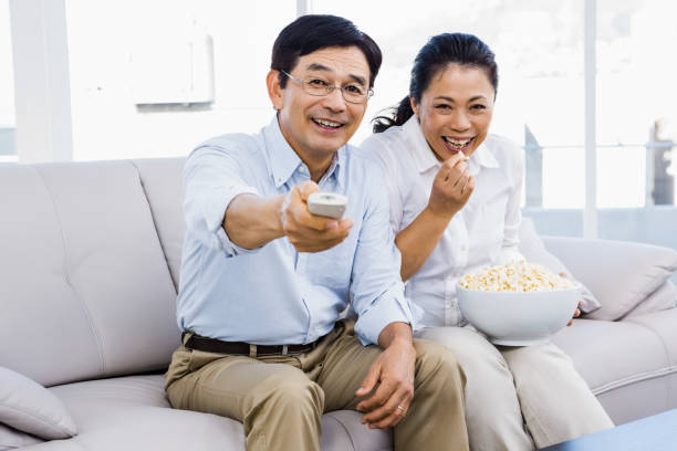 istock Smiling man and woman sitting on couch 668256334