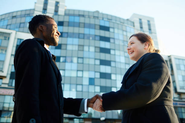 istock Business Colleagues Shaking Hands Outside Office Building 668256596