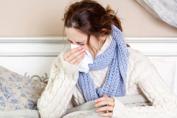 istock Sick young woman with blue scarf and suffering from terrible headache while lying in bed. 668262208