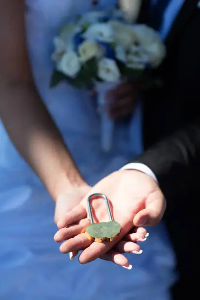 Wedding lock in the hands of the newlyweds.