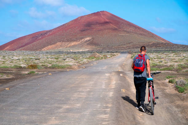 istock man with a bike in La Graciosa, Spain 668271022