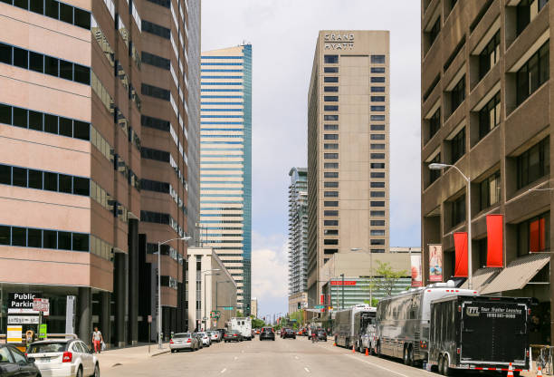 Denver, USA - May 25, 2016: Skyscrapers in the 17th street in downtown including the Dominion Towers and the Grand Hyatt hotel. Cars are driving and parked on the side of the street.